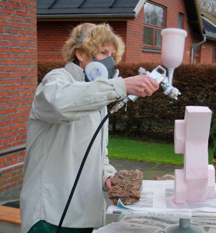 Kate arbejder med glasering af keramik med sprøjtepistol